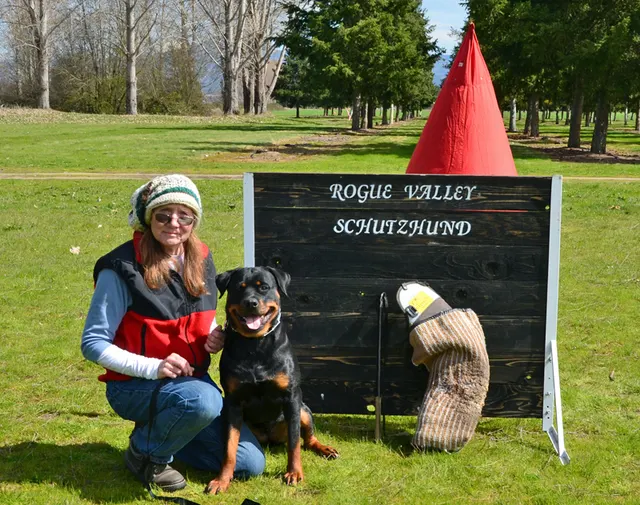 March 24, 2013 RVSC Club Training on March 24, 2013 — a club member posing with a working dog beside the RVSC field sign — photo 02
