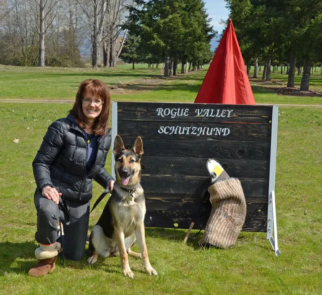 March 24, 2013 RVSC Club Training on March 24, 2013 — a handler and German Shepherd posing beside the Rogue Valley Schutzhund sign — photo 05